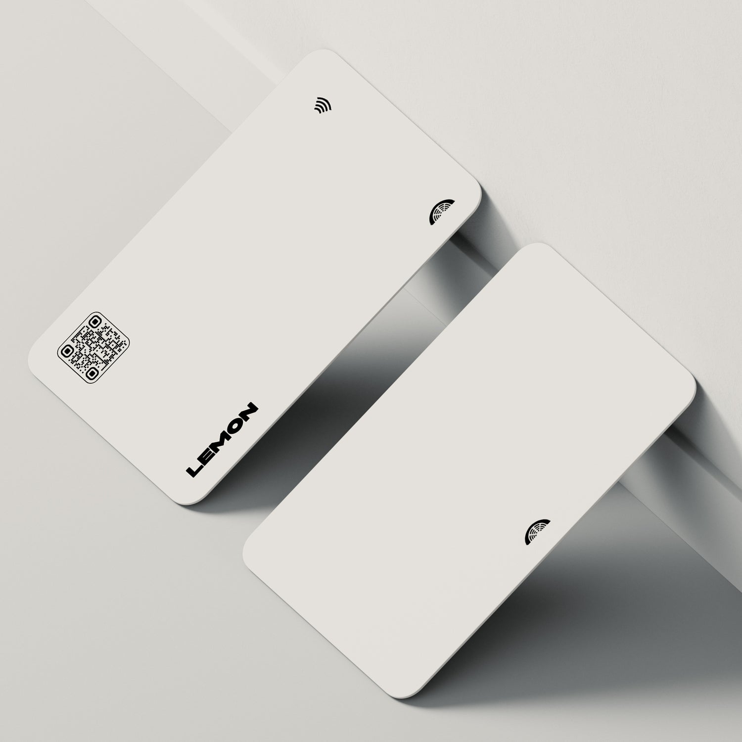 Two NFC-enabled white business cards stacked atop one another.